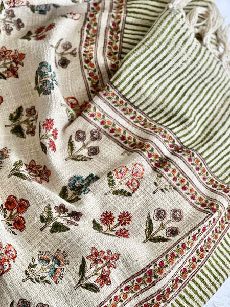 Textile with floral patterns and green stripes on a white background