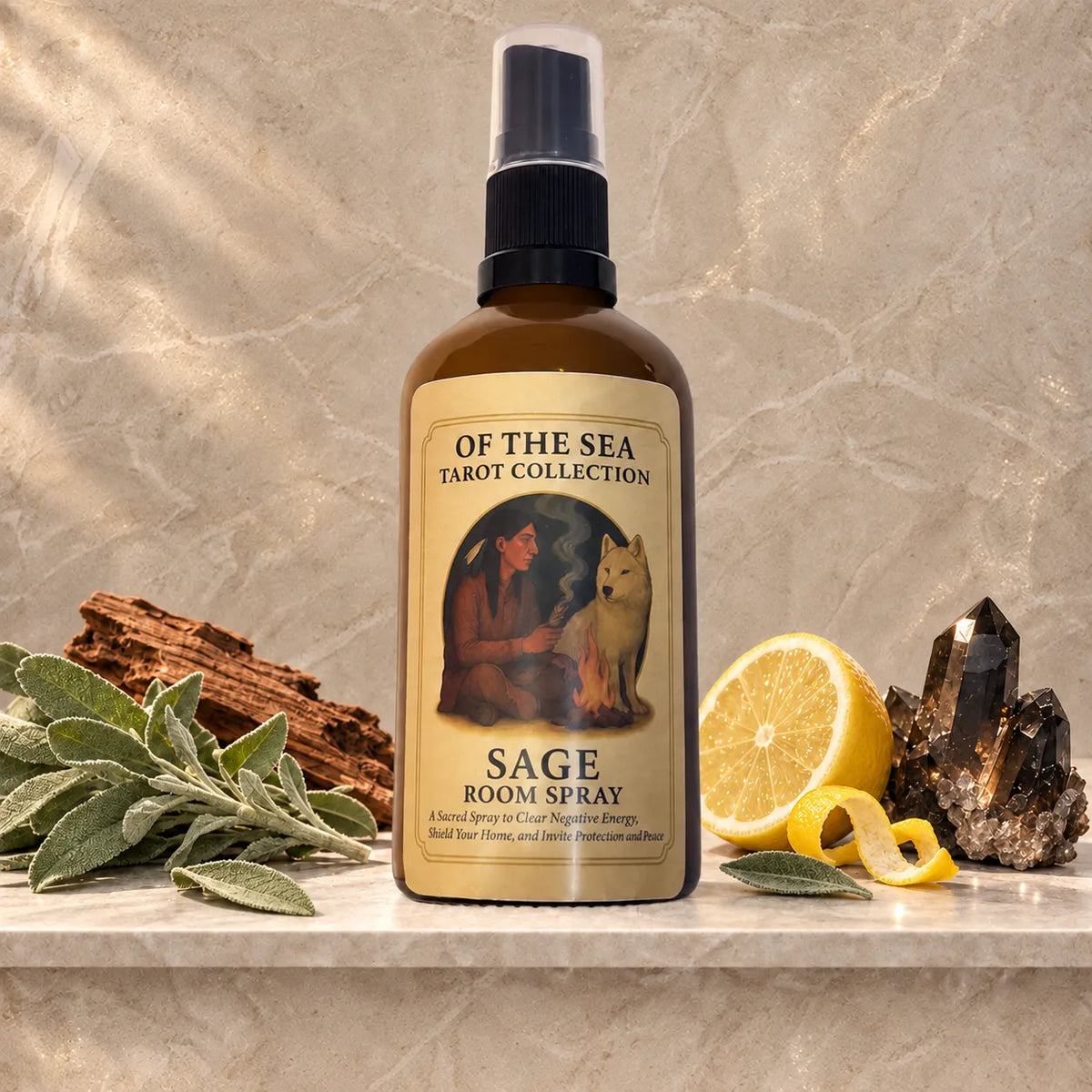 A bottle of Sage Room Spray from The of the Sea Tarot Collection sits on a marble shelf styled with sage leaves, a lemon half, and crystals against a textured beige background.