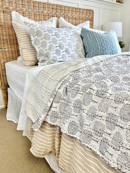 Bed with patterned quilt and pillows in a bedroom setting