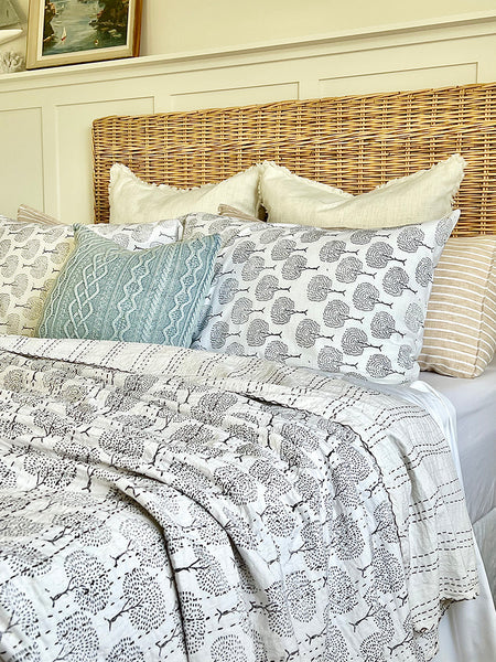 Bed with patterned bedding and pillows in a bedroom setting
