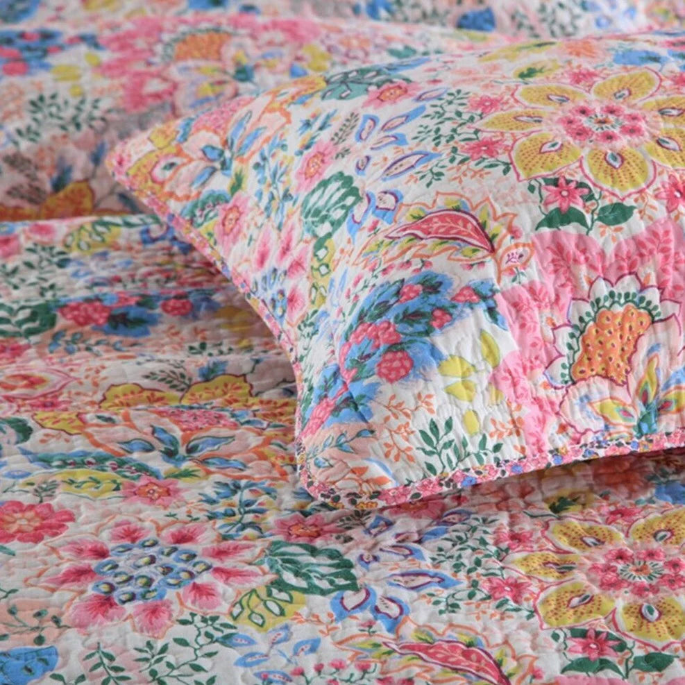 Floral patterned bedding set with colorful flowers on a bedspread.