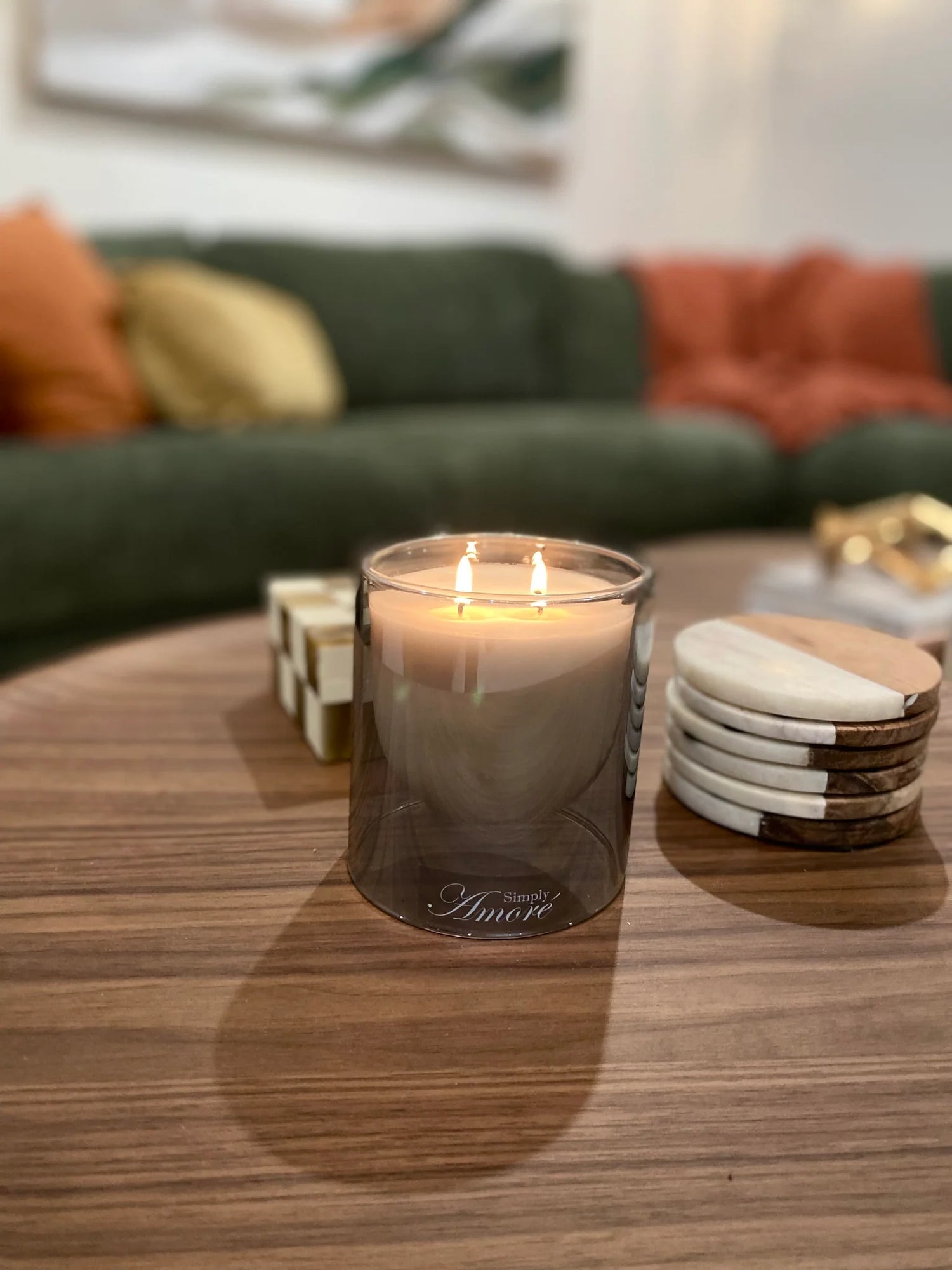 Candle in a glass holder on a wooden table with a blurred background