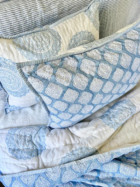 Blue and white patterned quilt on a sofa