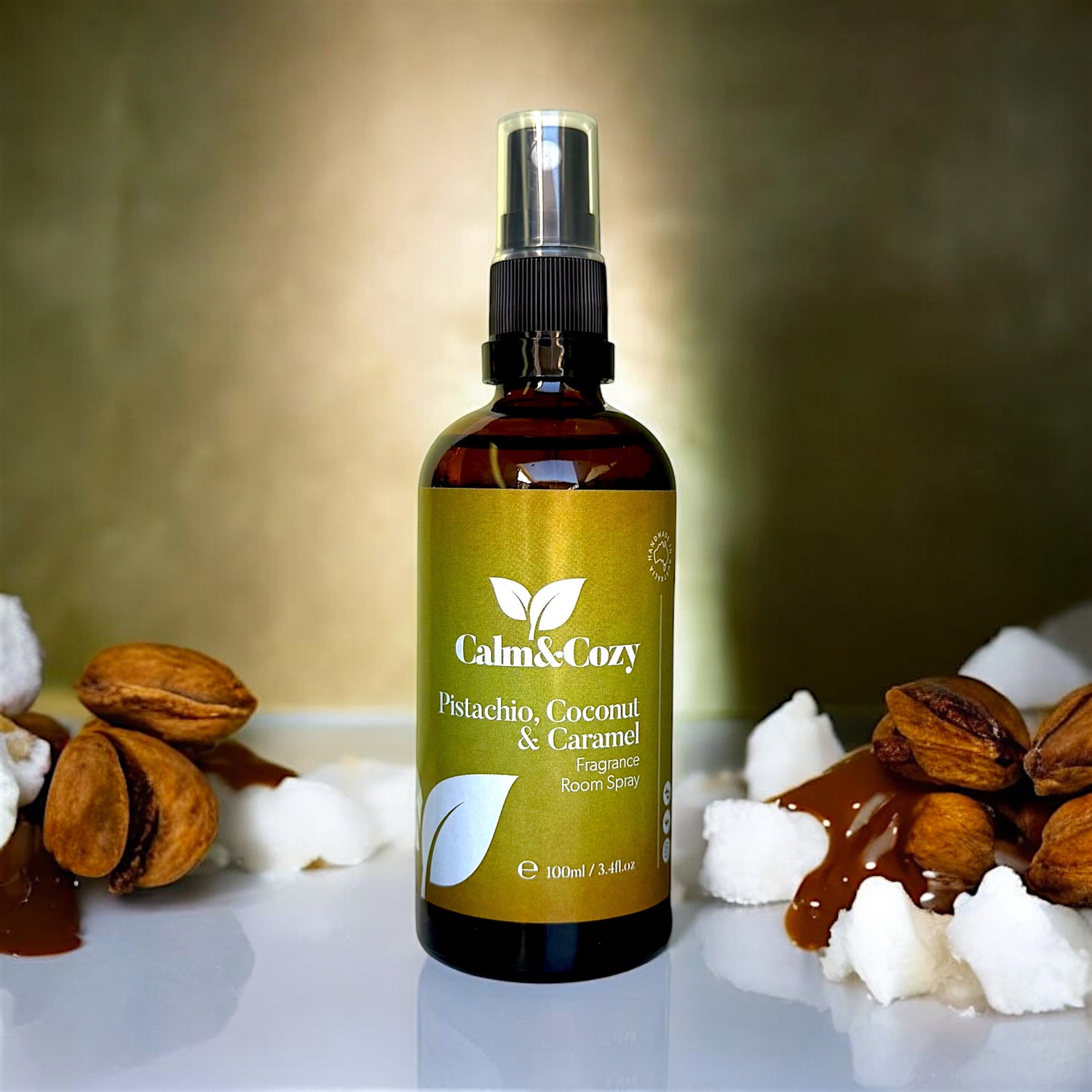 Bottle of Calm & Cozy room spray with pistachio, coconut, and caramel ingredients on a textured surface.
