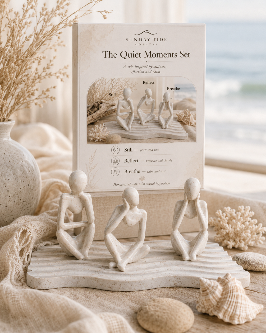 The Quiet Moments Set by Sunday Tide Design, featuring three small beige stone figurines in seated meditation poses on a wave-patterned base, styled with seashells, dried grass, and a neutral fabric backdrop.
