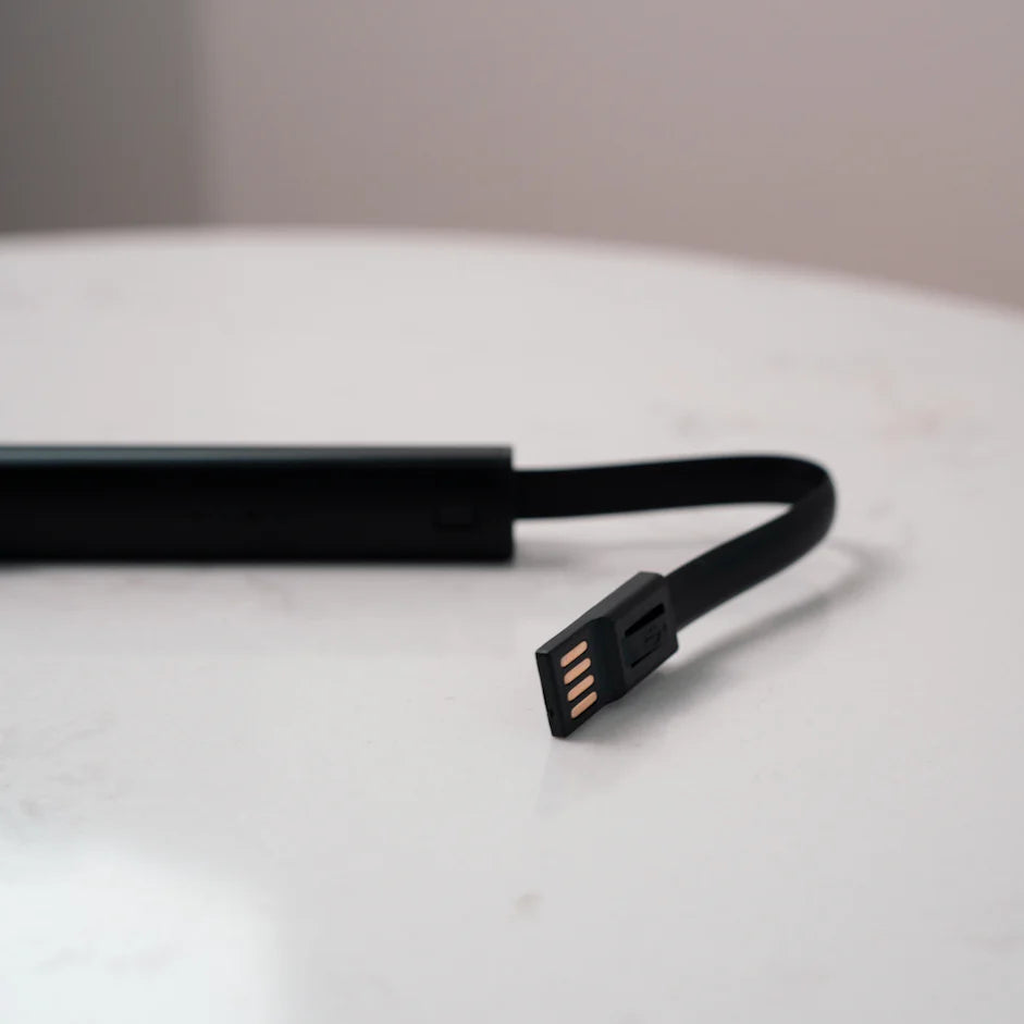 Black USB cable on a white surface