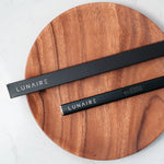 Two black LUNAIRE products on a wooden surface