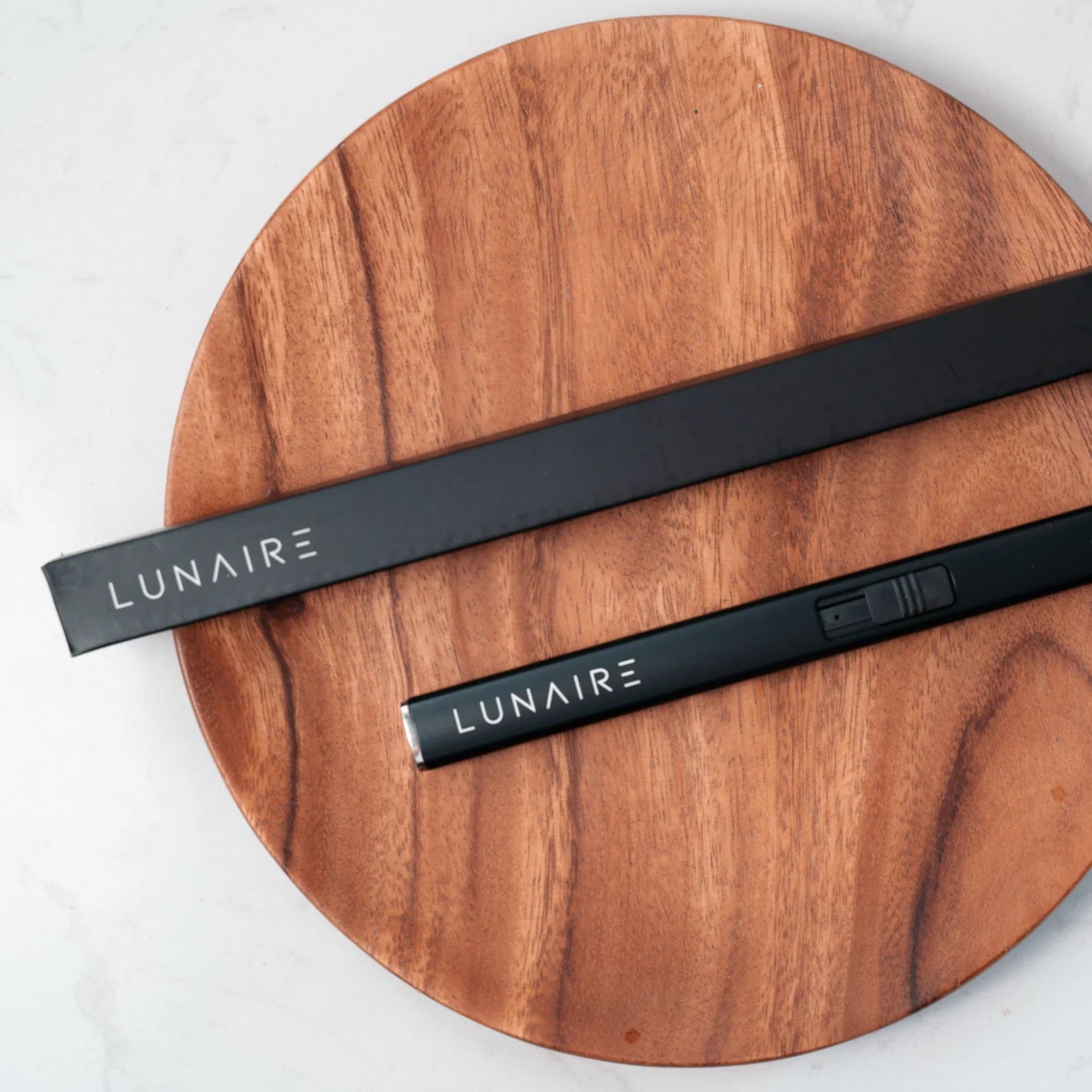 Two black LUNAIRE products on a wooden surface