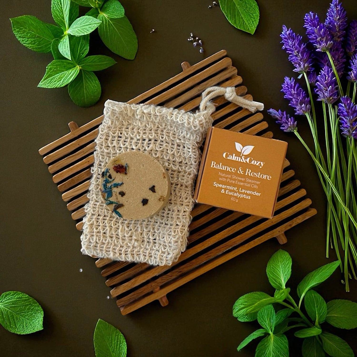 Natural soap on a wooden soap dish with lavender and green leaves on a brown background