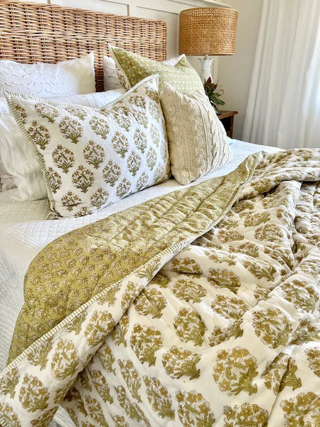 Bed with patterned bedding and pillows in a bedroom setting