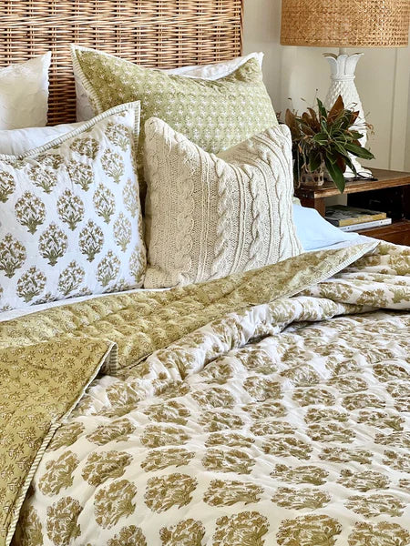 Bed with patterned bedding and pillows in a bedroom setting