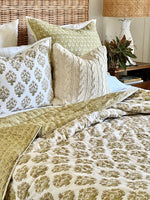 Bed with patterned bedding and pillows in a bedroom setting