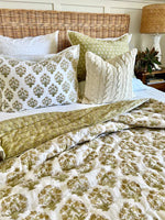 Bed with patterned bedding and pillows in a bedroom setting