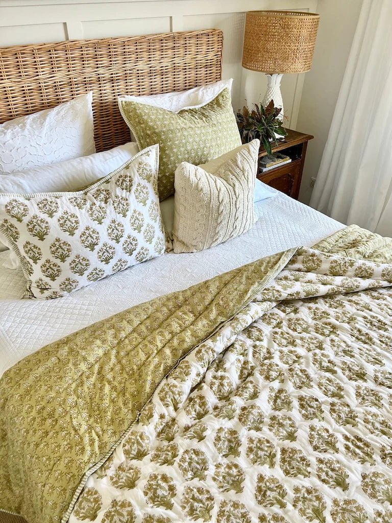 Bed with patterned bedding and pillows in a bedroom setting