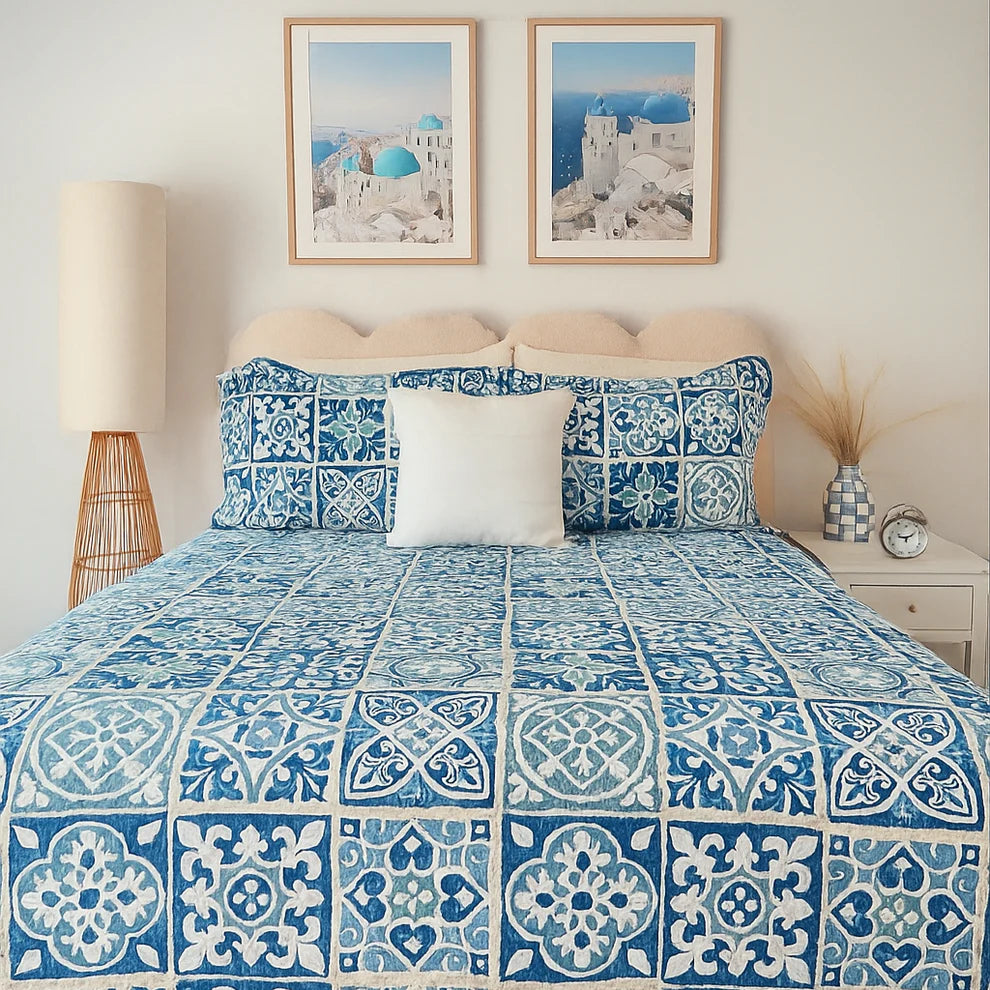 Bedroom with blue and white patterned bedding, framed artwork, and decorative items.