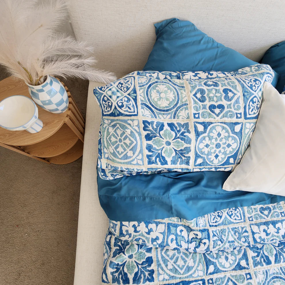 Decorative pillows with blue and white patterns on a beige sofa.