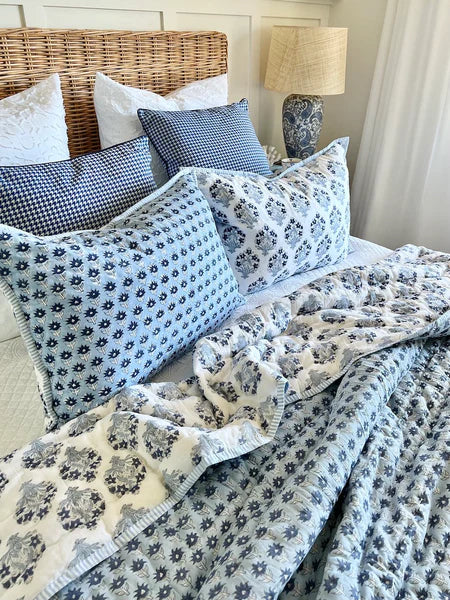 Bed with floral bedding and pillows in a bedroom setting