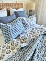 Bed with floral bedding and pillows in a bedroom setting