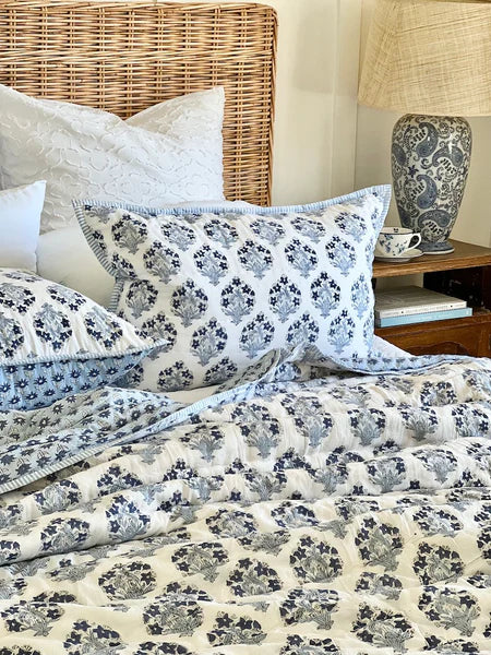 Bed with floral bedding and pillows in a bedroom setting