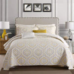Bedroom with a bed featuring a patterned comforter and pillows, flanked by lamps and decorative items.