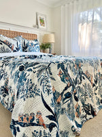 Bed with floral and nature-themed quilt in a bright bedroom