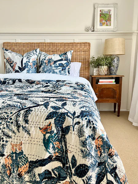 Bedroom with floral-patterned bedding and a wooden nightstand.
