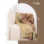Decorative blanket draped over a chair with 'Toile' text above