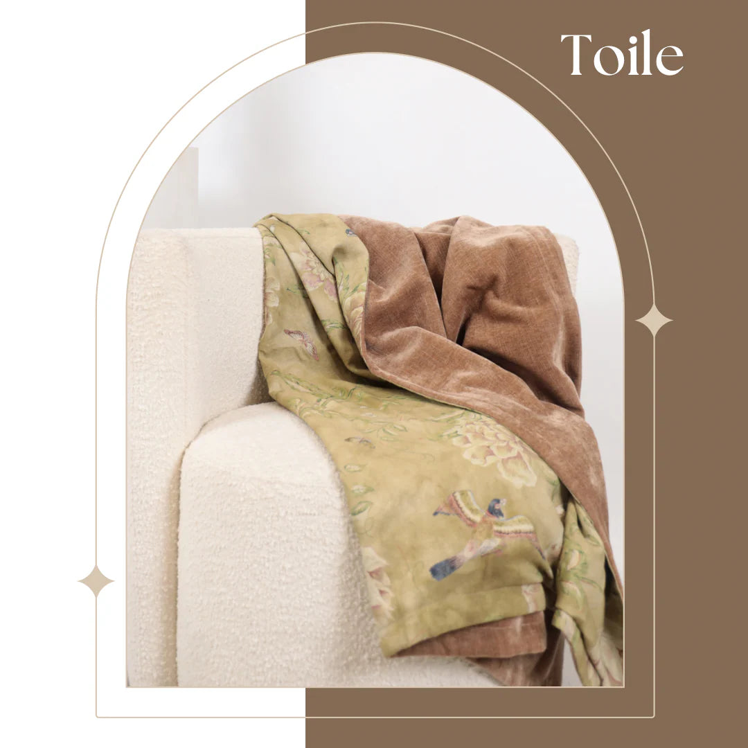 Decorative blanket draped over a chair with 'Toile' text above