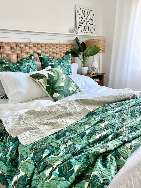 Bedroom with green leaf-patterned bedding and pillows