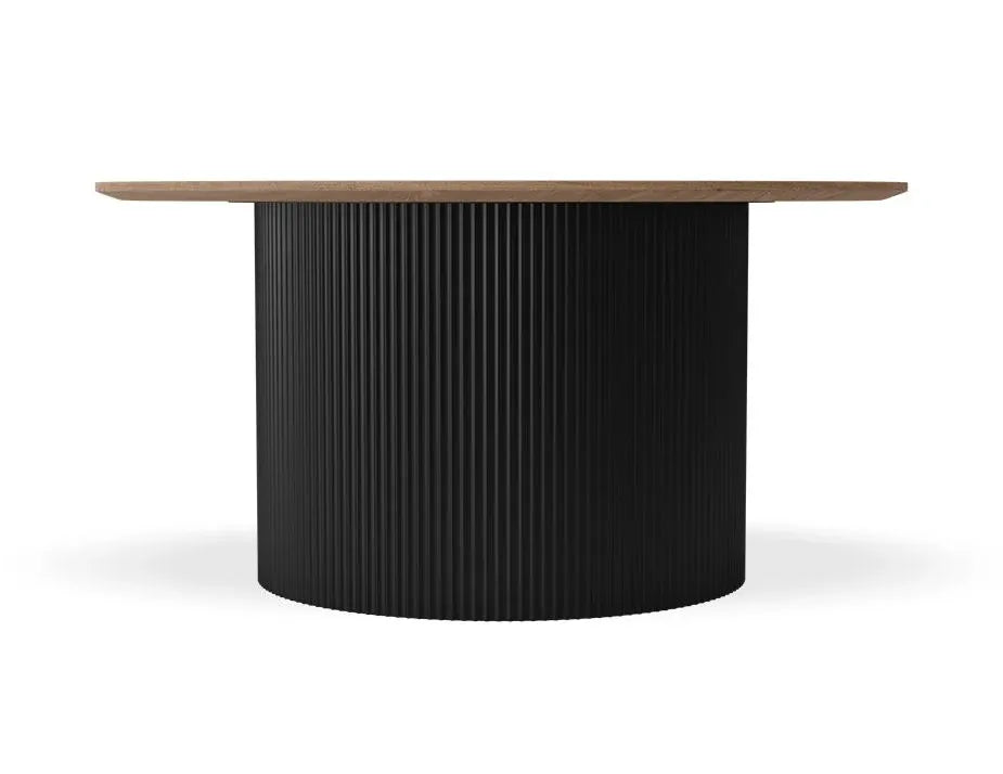 A modern round dining table featuring a fluted black pedestal base and a light brown wood top, shown against a plain white background.