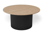 A round coffee table with a light oak wood-grain top and a black ribbed cylindrical pedestal base, shown on a clean white background.