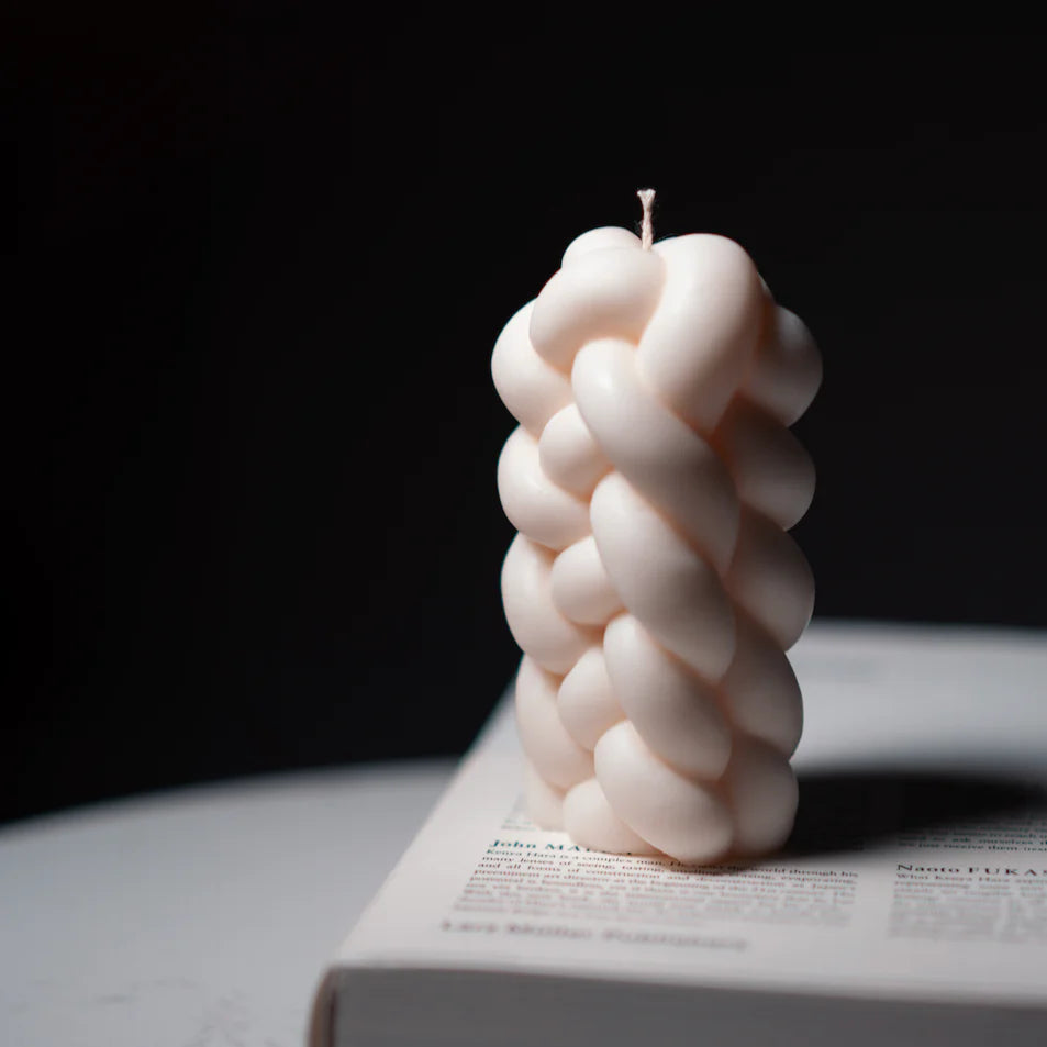 Textured candle on a book with a dark background