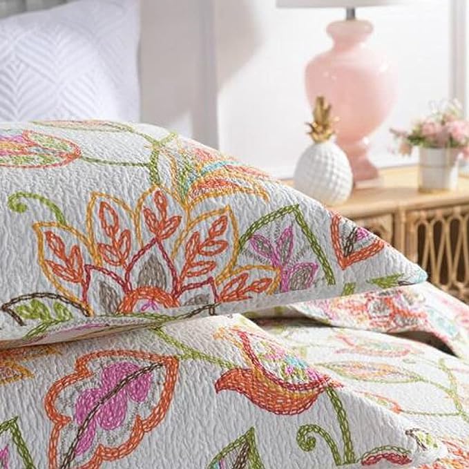 Floral patterned quilt on a bed with a blurred background