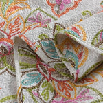 Close-up of a colorful embroidered quilt with intricate patterns.