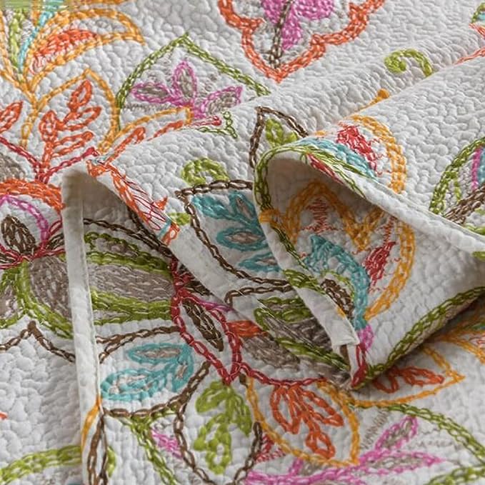 Close-up of a colorful embroidered quilt with intricate patterns.