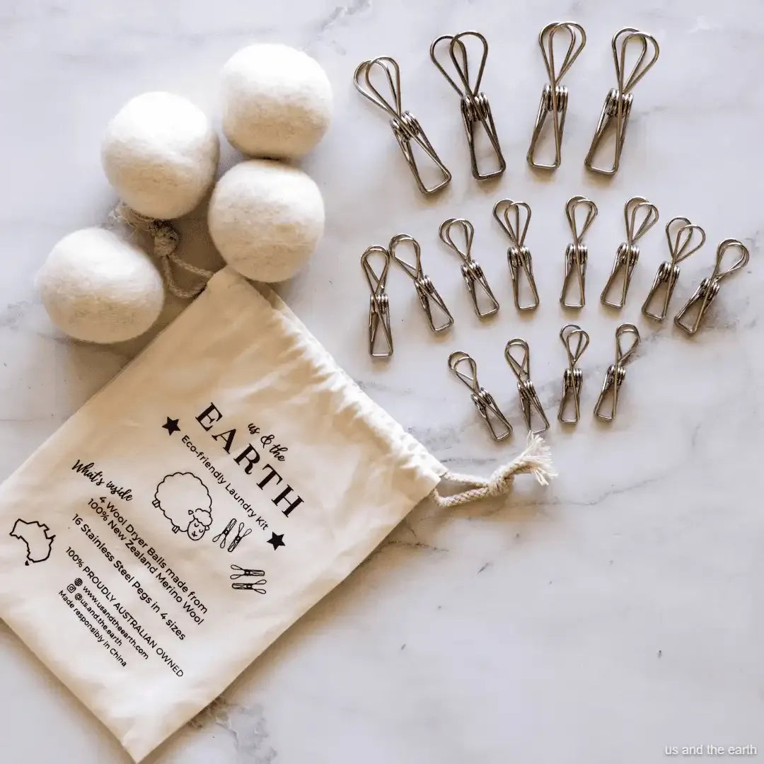 Set of natural laundry balls, clips, and a drawstring bag labeled 'Out of the Earth' on a marble surface.