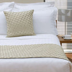Neatly made bed featuring Jason Regency Champagne Square Cushion on white linens