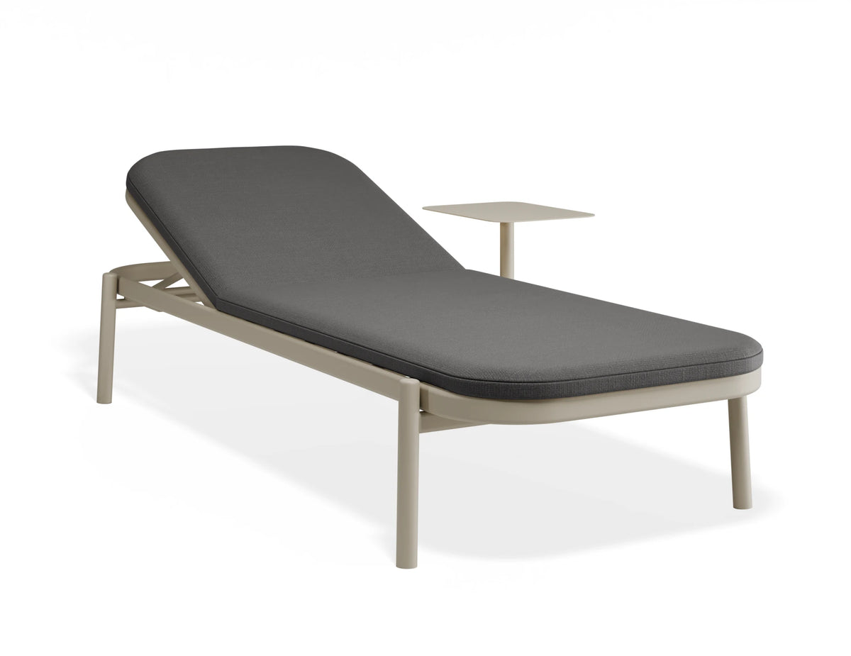 A modern outdoor chaise lounge chair with a dark gray cushioned seat and a light beige metal frame, featuring an integrated side table, shown on a white background.