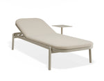 A modern outdoor chaise lounge chair with a light beige cushioned seat and backrest, a matching light beige metal frame, and an integrated side table, shown on a white background.