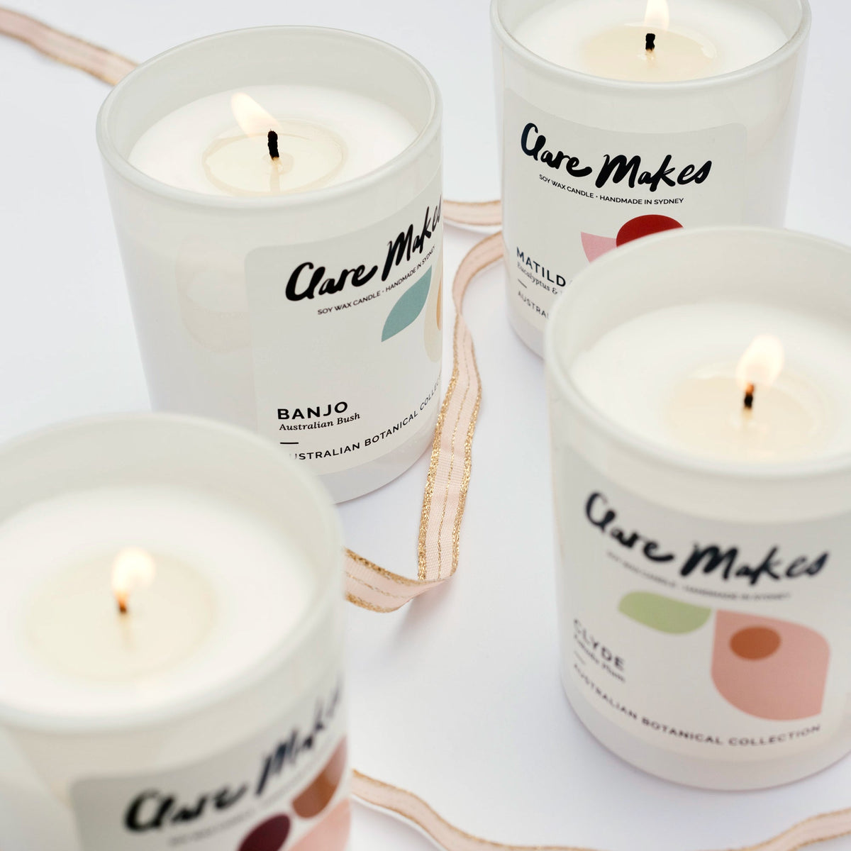 Clare Makes medium soy candle in a reusable gloss white glass jar with a branded dust cover